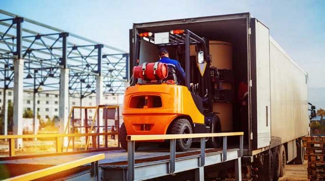 Vorkheftruck laadt dozen in een vrachtwagen