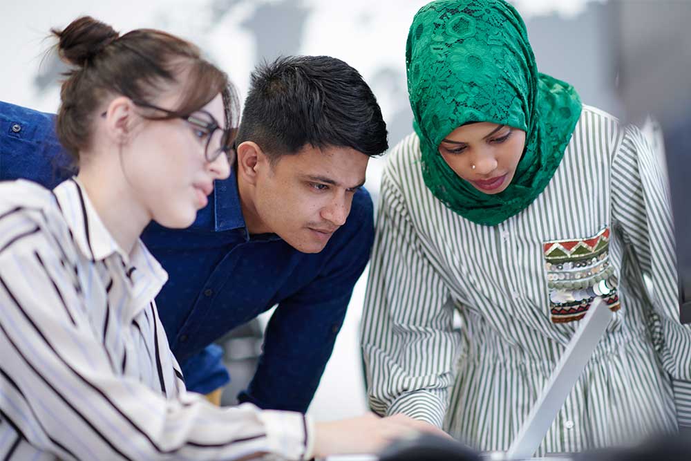 Three colleagues looking at computer